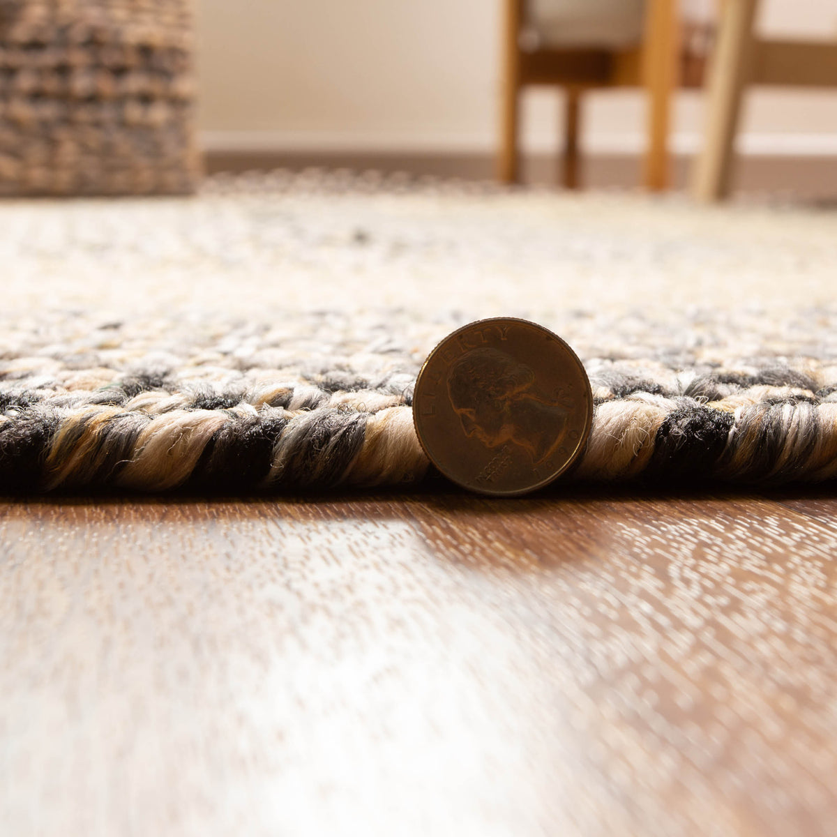 Ridgewood gray braided wool rug - edge thickness shown against a quarter, low profile that lays flat
