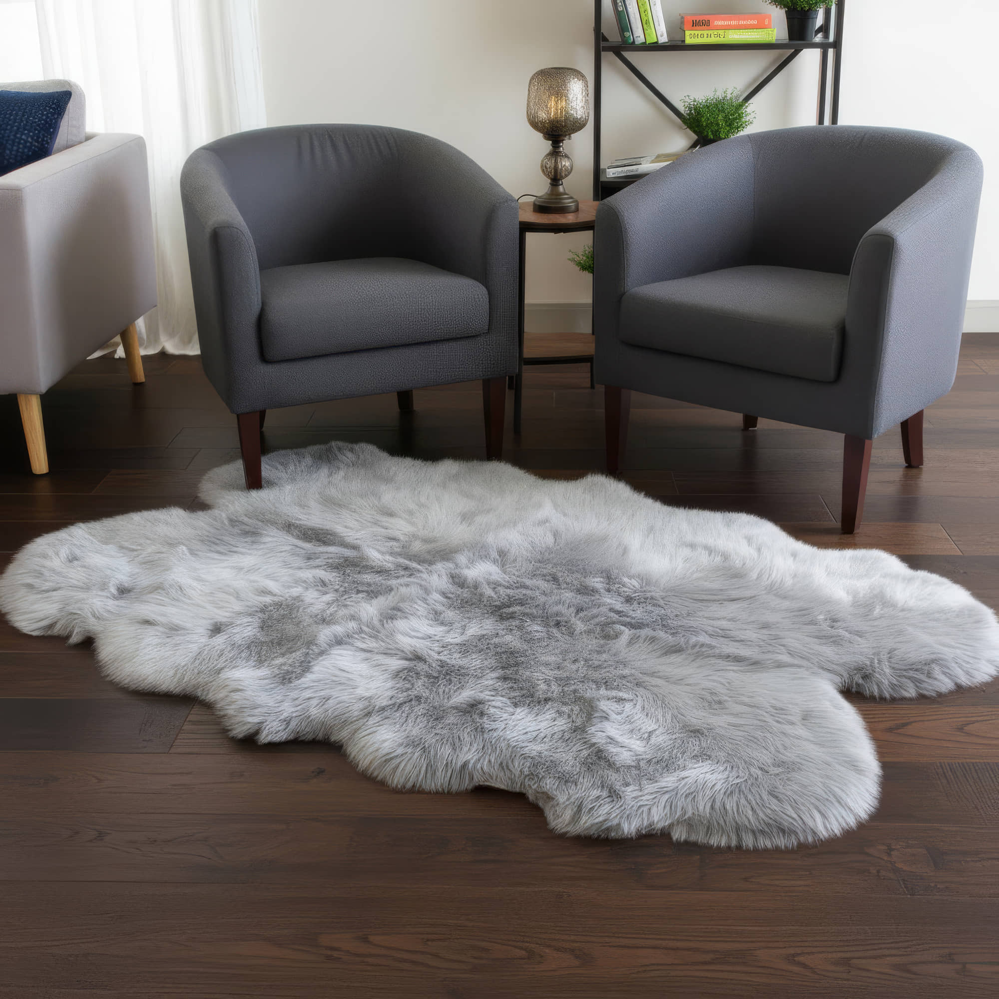 Gray fur rug on a wooden floor with gray chairs in the background #size_4' x 6'