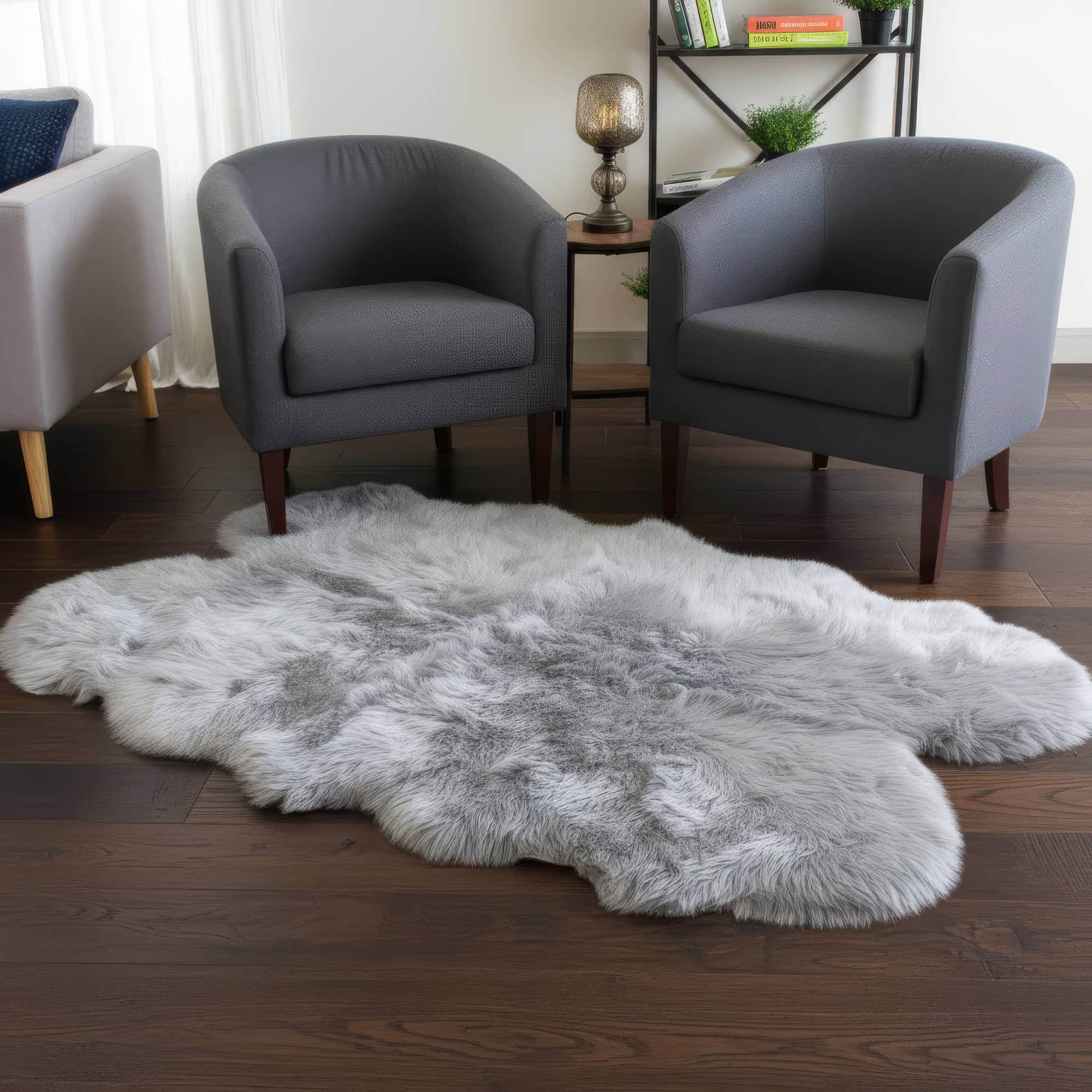 Gray fur rug on a wooden floor with gray chairs in the background #size_4' x 6'