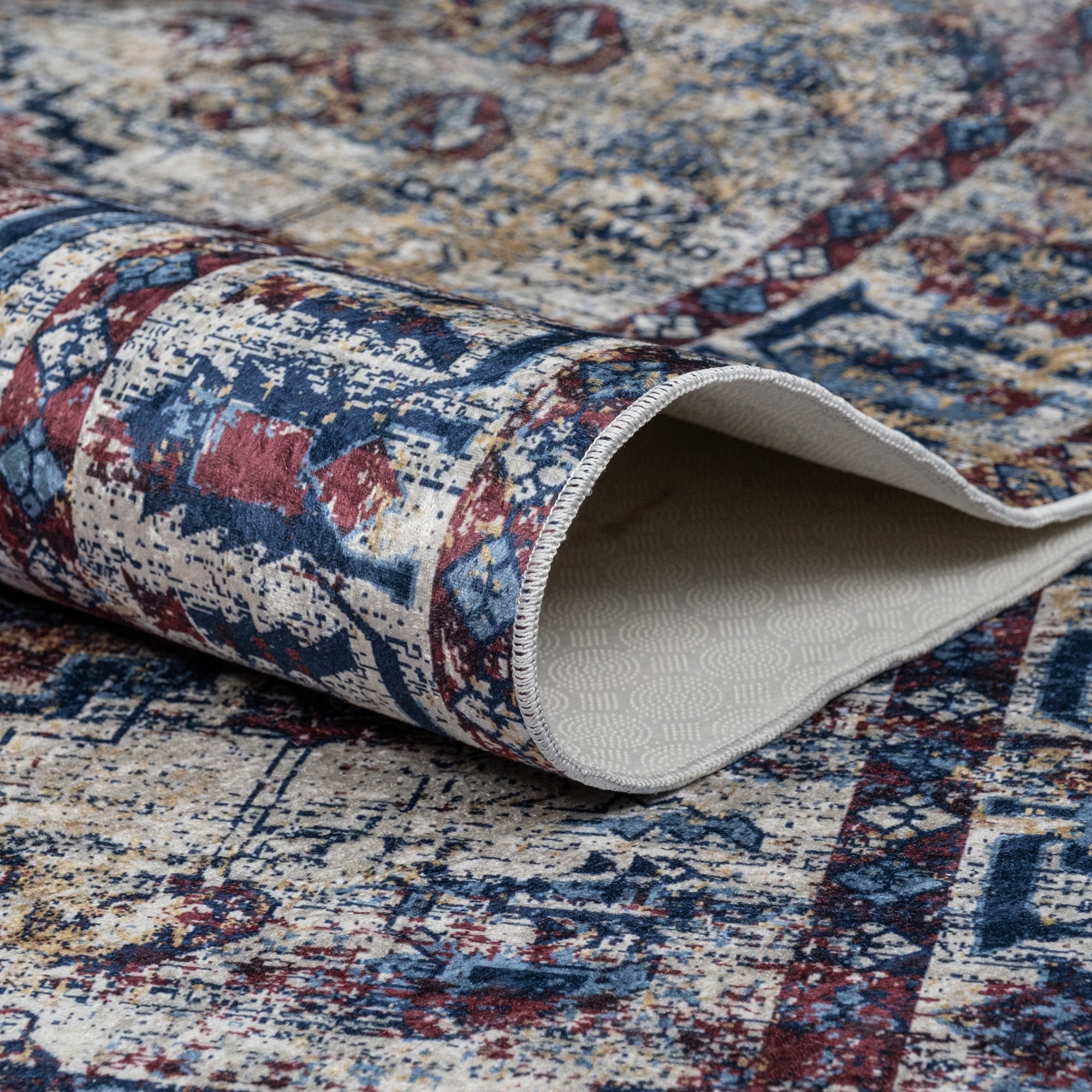 Red Bursa machine washable area rug 5' x 7' - folded to show the non-slip backing