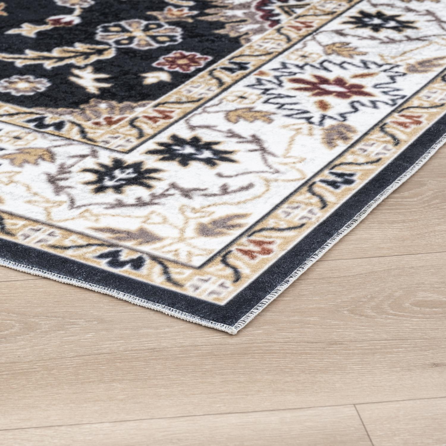Black Bursa machine washable area rug 4' x 6' - corner detail on hardwood floor