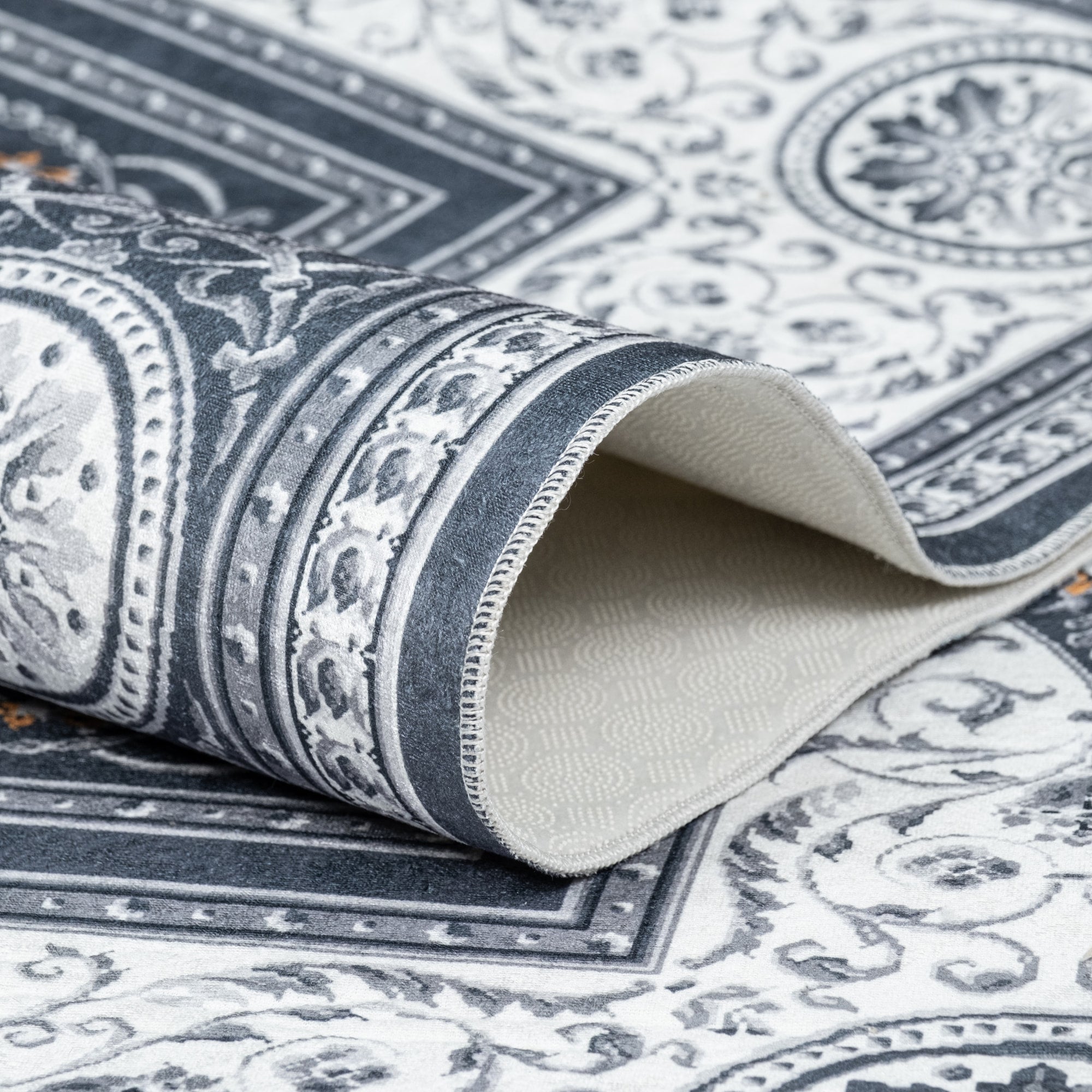 Gray Bursa machine washable area rug 4' x 6' - folded to show the non-slip backing