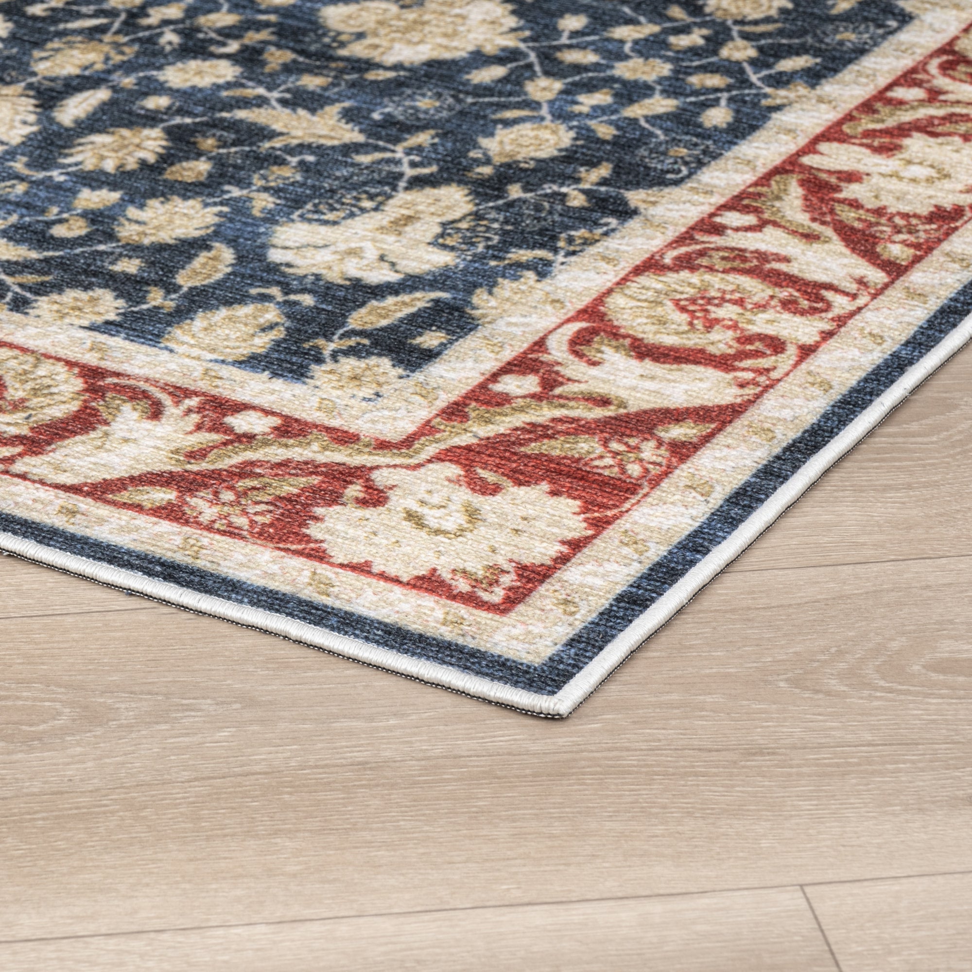 Navy Konya machine washable area rug 2' x 3' - corner detail on hardwood floor