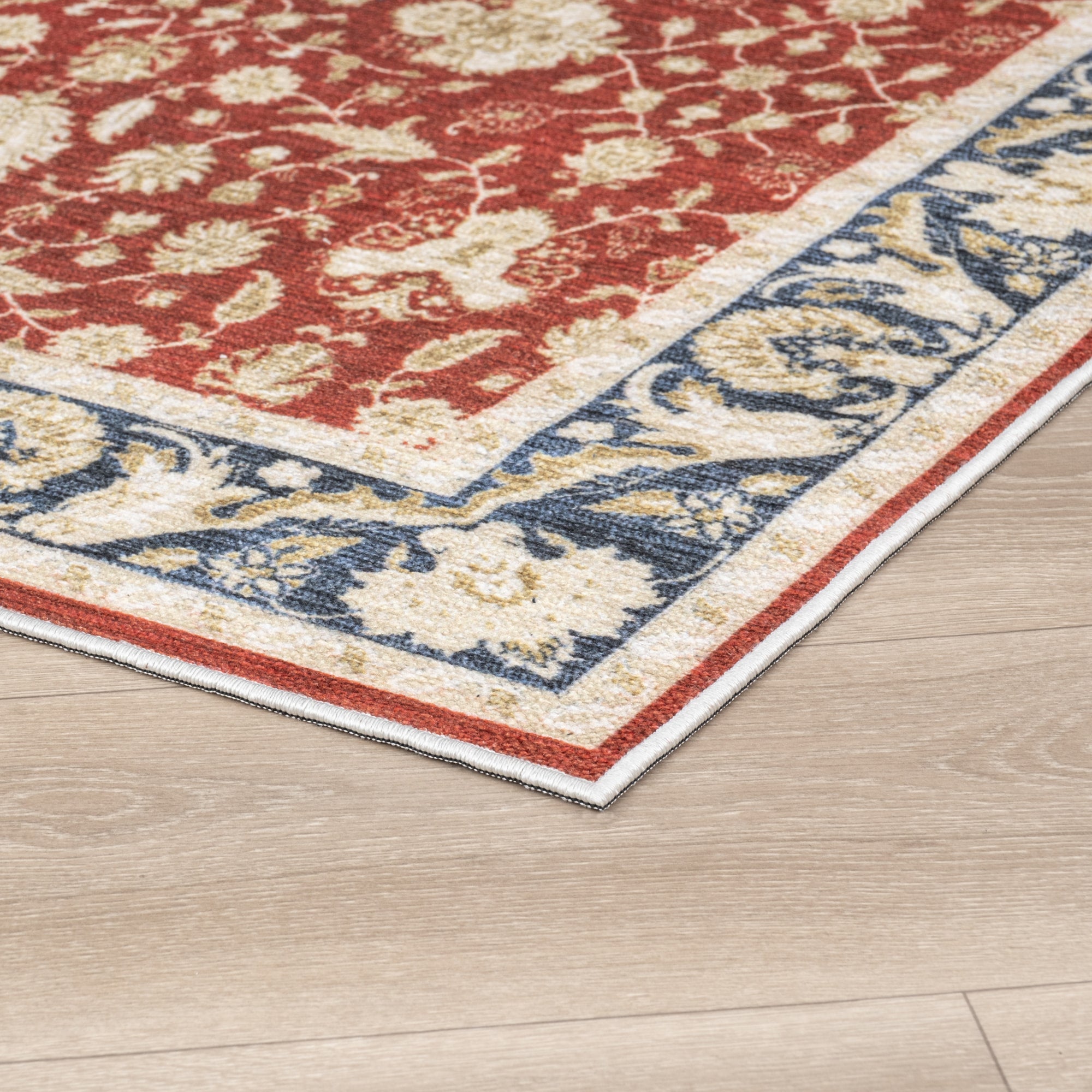 Red Konya machine washable area rug 2' x 3' - corner detail on hardwood floor