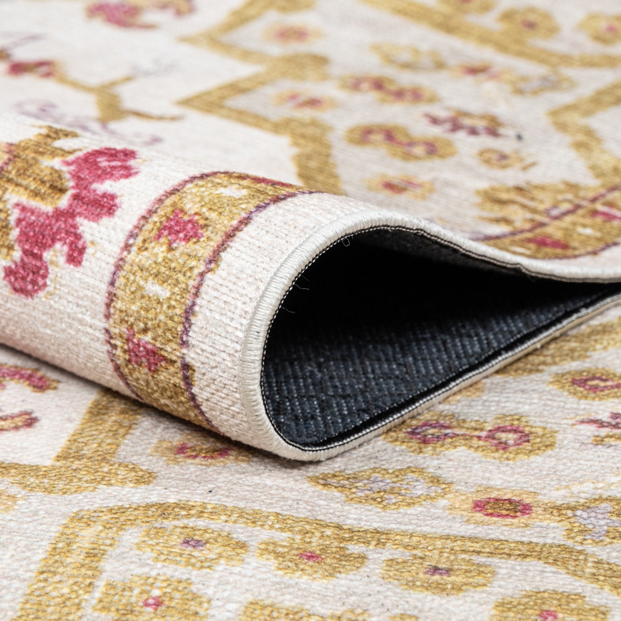 Ivory Konya machine washable area rug 4' x 6' - folded to show the non-slip backing