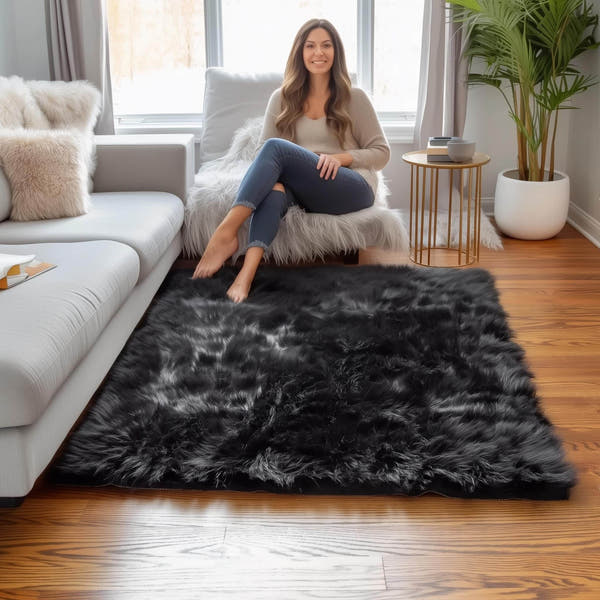 4x6 black faux fur area rug in a bright living room with a light gray sofa #Size_4' x 6'
