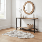 Console table with decorative items in a room with a round mirror and rug. #size_2' x 3'