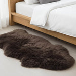 Brown fur rug on a light wooden floor with a bed in the background #size_2' x 3'