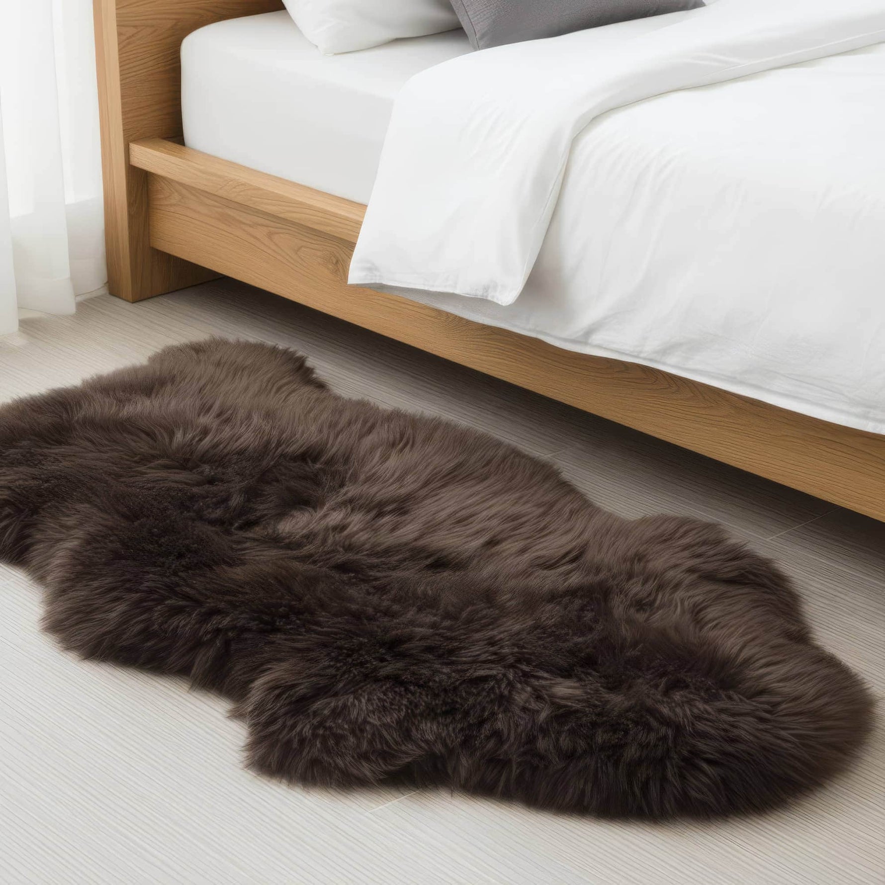 Brown fur rug on a light wooden floor with a bed in the background #size_2' x 3'