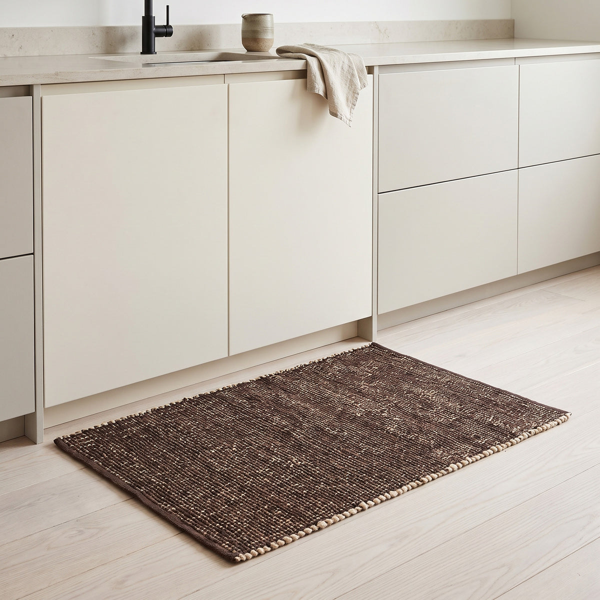 Terra brown jute and cotton rug, 2' x 3', in a kitchen