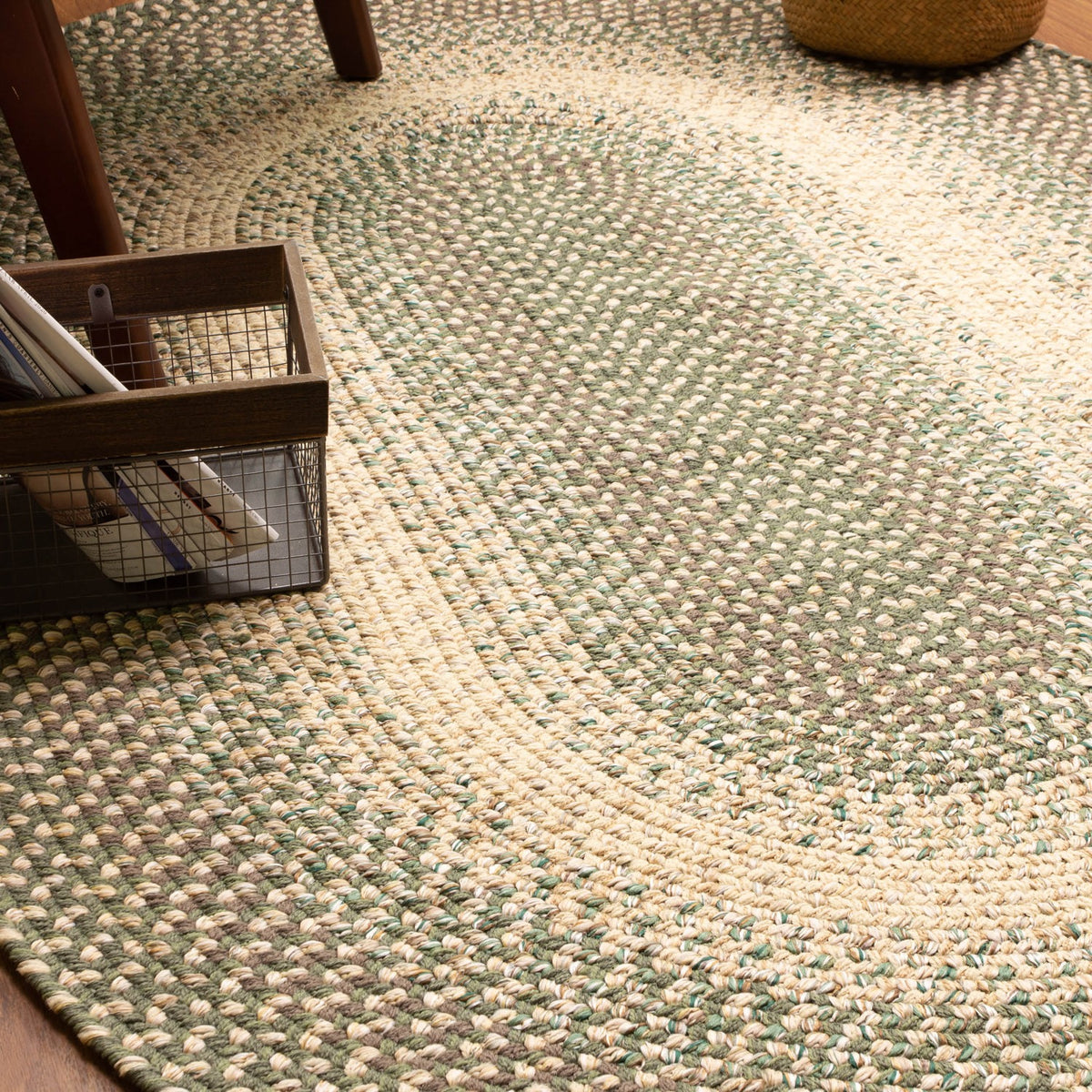 Ridgewood Forest Green braided rug - edge detail styled with books and a wire basket