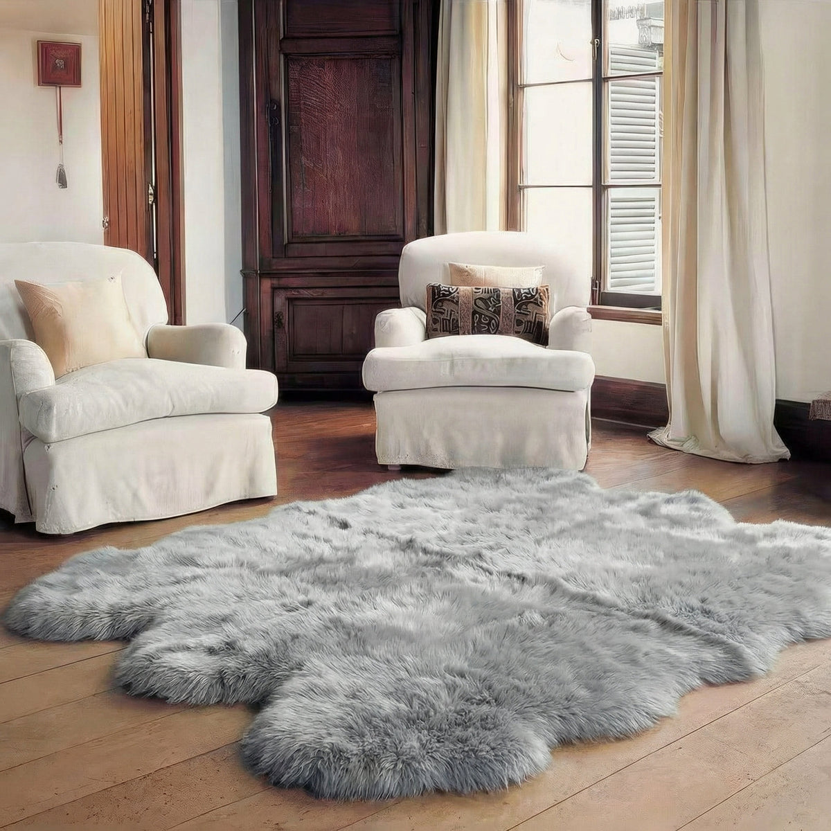 Silver gray sheepskin rug on hardwood between two white slipcovered armchairs #size_Sexto (6-Pelt) 5×6 ft