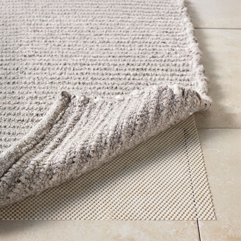 Outdoor rug pad under an outdoor rug on a patio