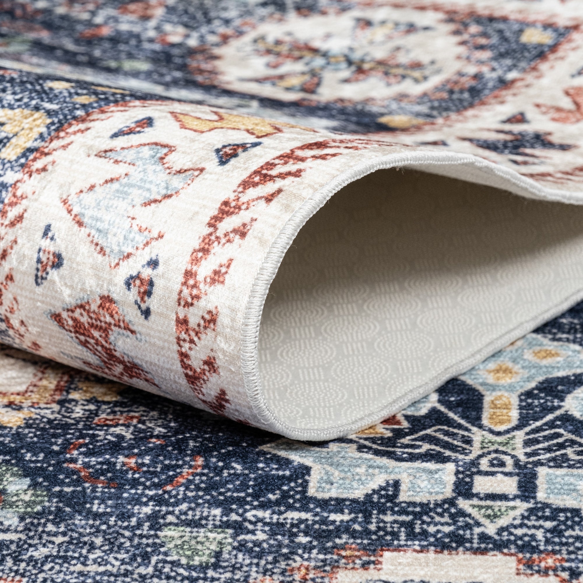 Pastel Bursa machine washable area rug 2' x 3' - folded to show the non-slip backing