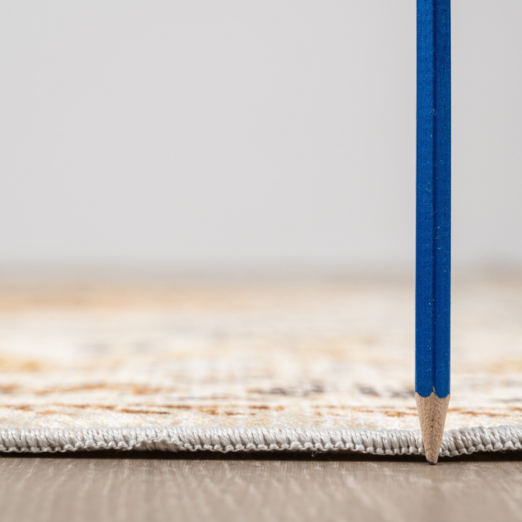 Olive Bursa machine washable area rug 3' x 5' - low pile height next to a pencil