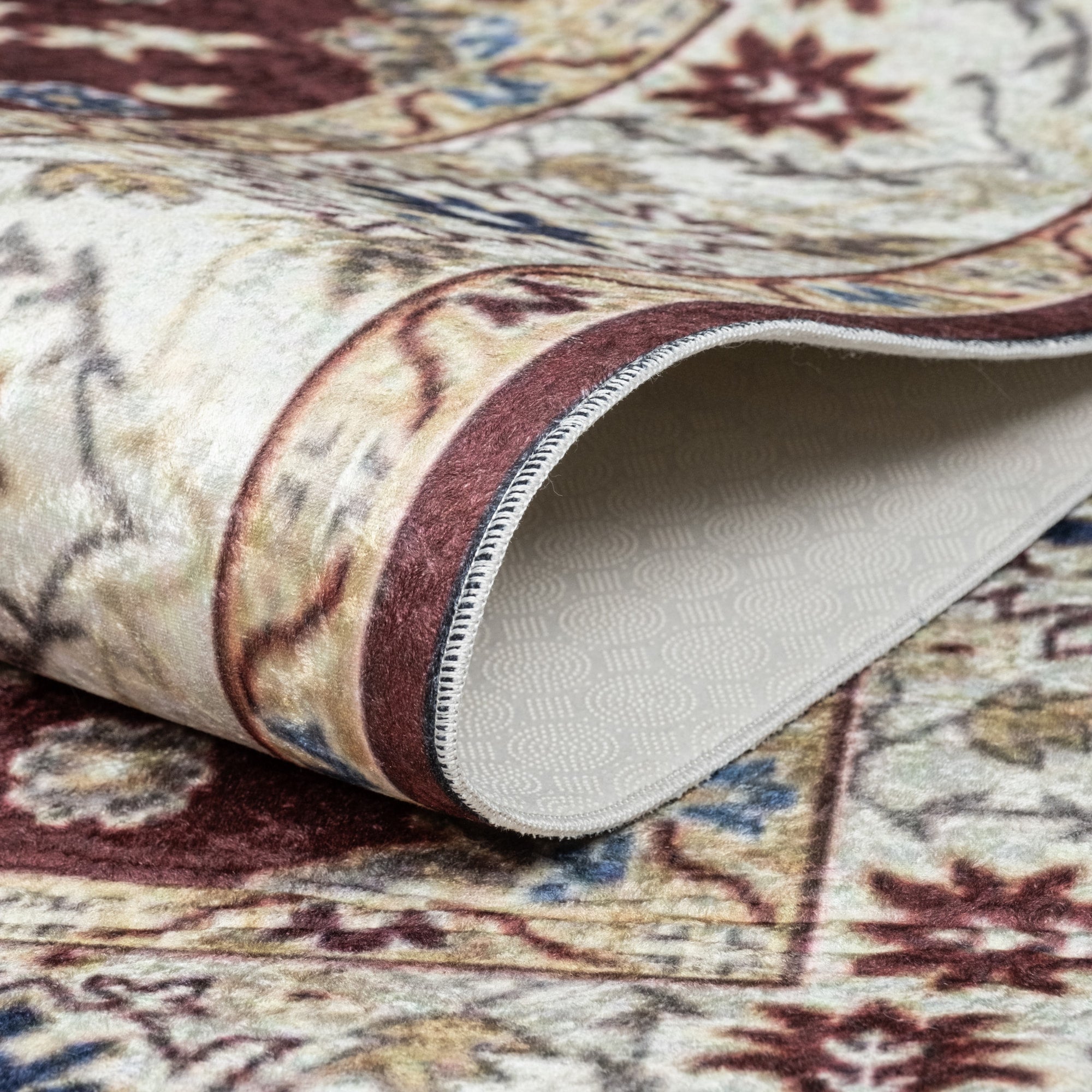 Burgundy Bursa machine washable area rug 5' x 7' - folded to show the non-slip backing