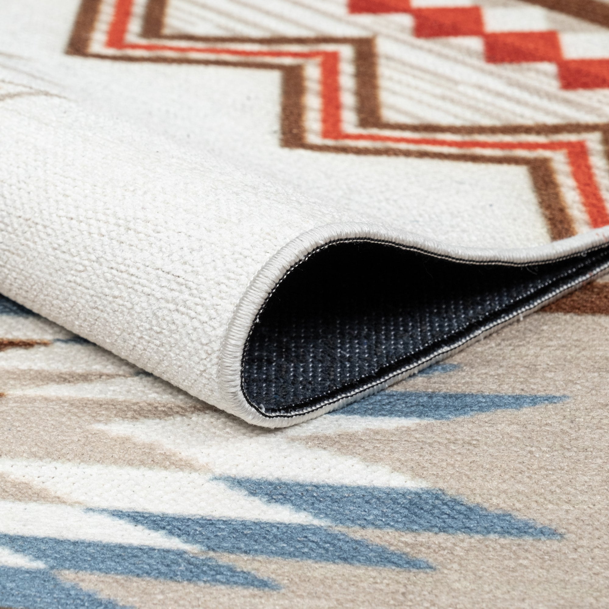 Ivory Konya machine washable area rug 4' x 6' - folded to show the non-slip backing