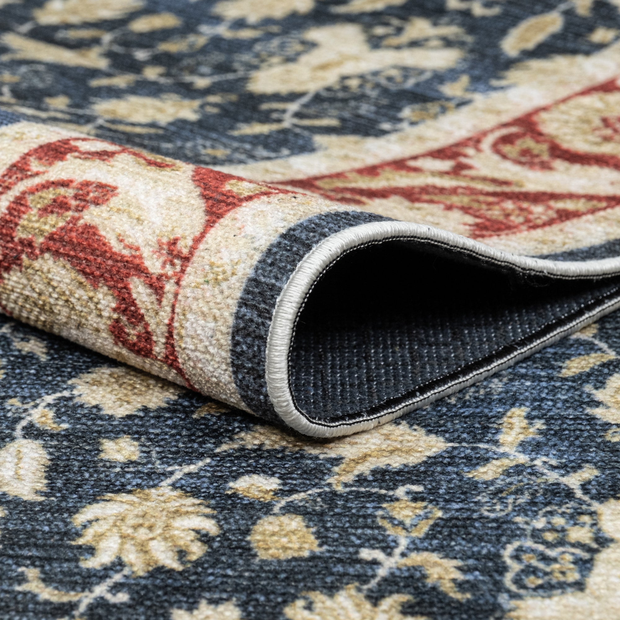 Navy Konya machine washable area rug 2' x 3' - folded to show the non-slip backing