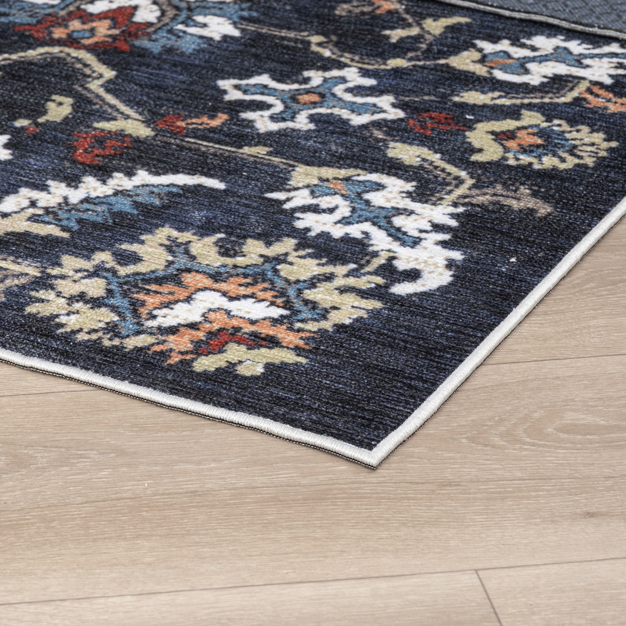 Navy Konya machine washable area rug 4' x 6' - corner detail on hardwood floor