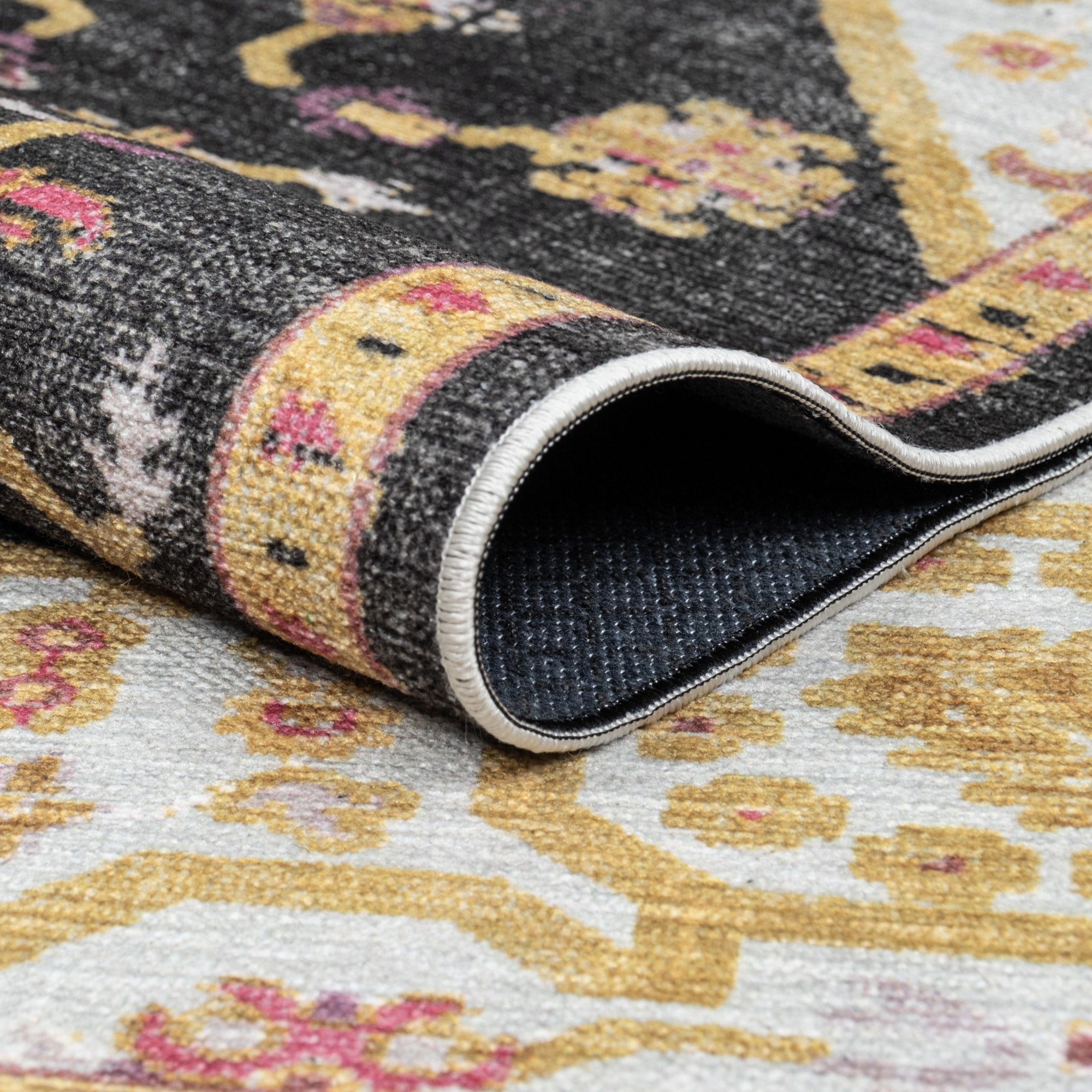 Charcoal Konya machine washable area rug 2' x 3' - folded to show the non-slip backing